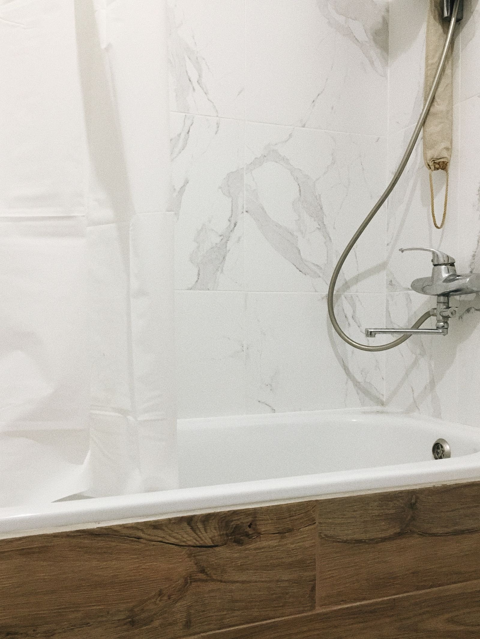 Bathtub set against marble tile