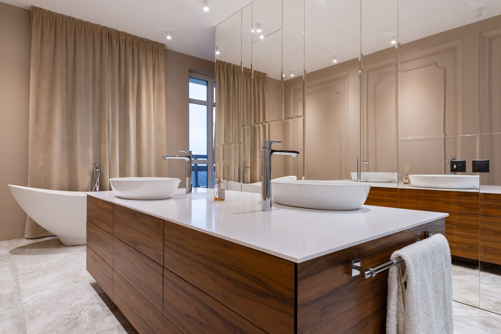 Spacious remodeled bathroom with a soaking tub, double vanity and warm wood finishes