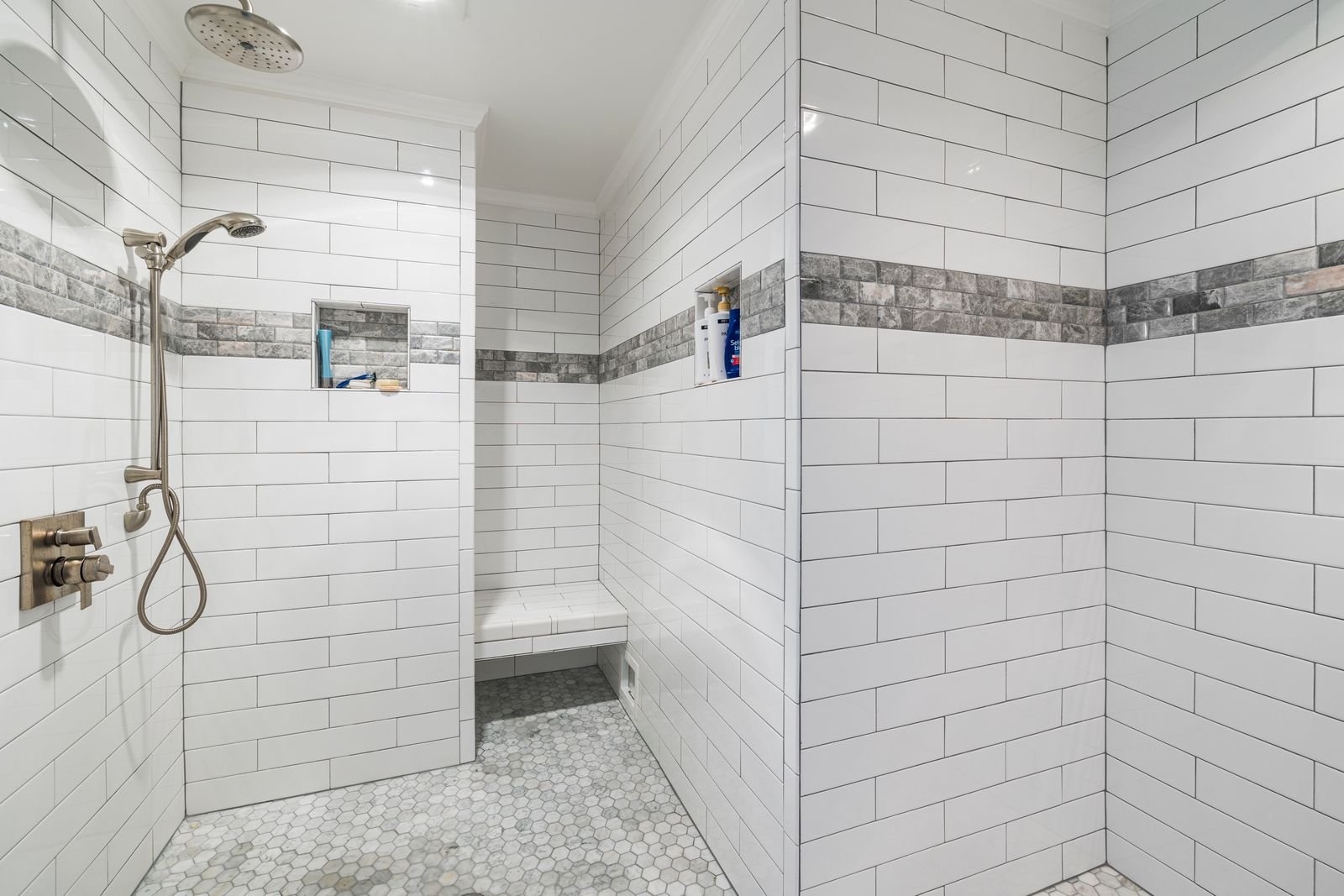 White tiled walk-in shower with a low entry